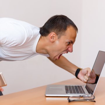 man screaming at laptop frustrated angry vpn services slow internet connection